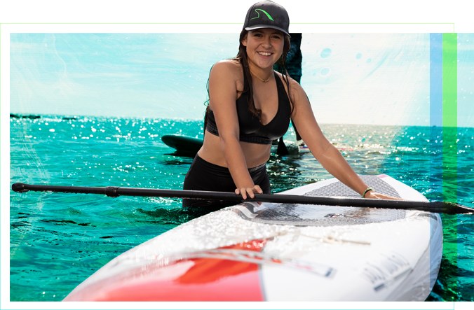 一个女学生站在水里，旁边是一个划桨板，桨横在上面.